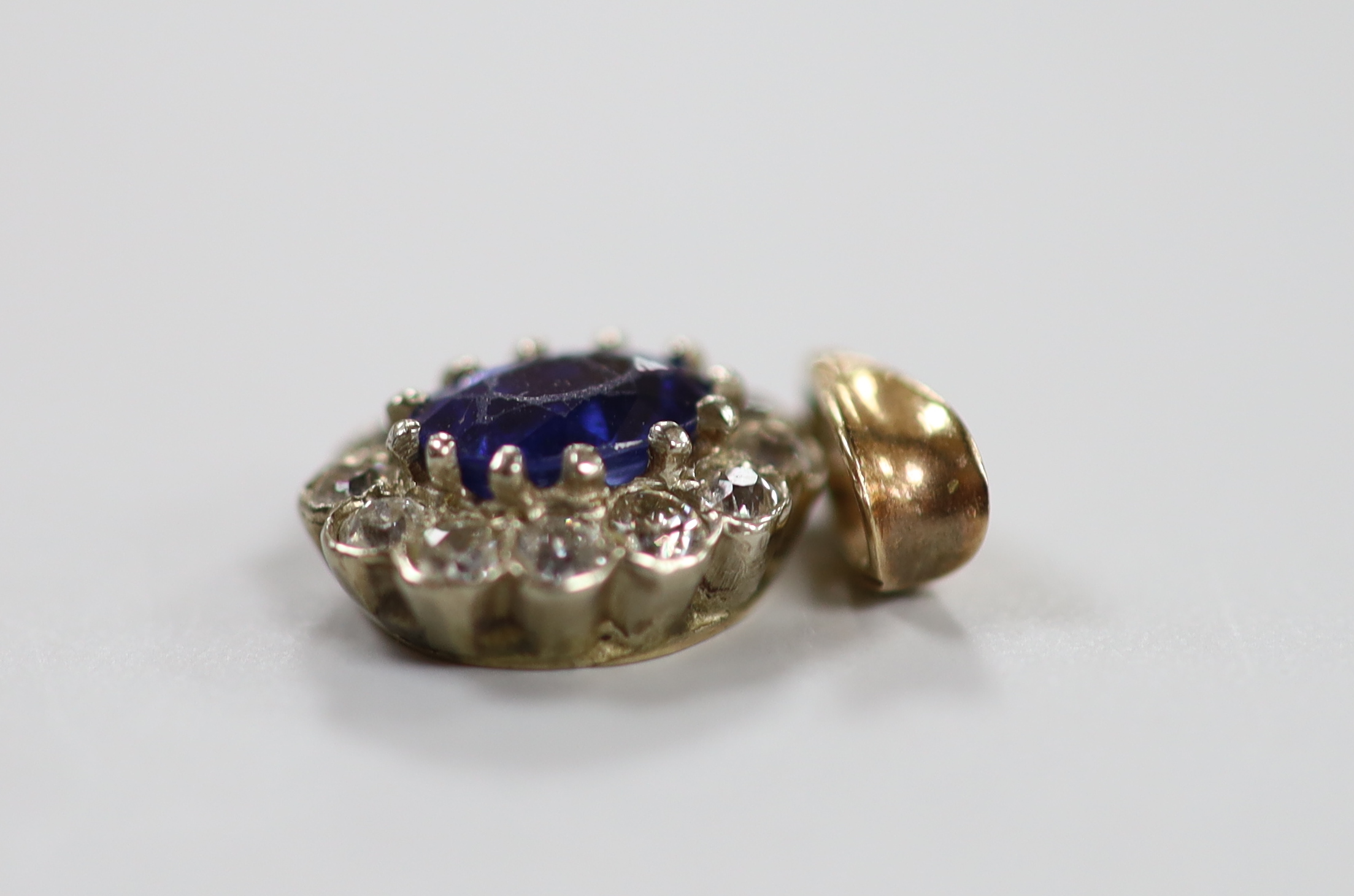 A yellow metal, sapphire and diamond set oval cluster pendant, 11mm, gross weight 1.6 grams.